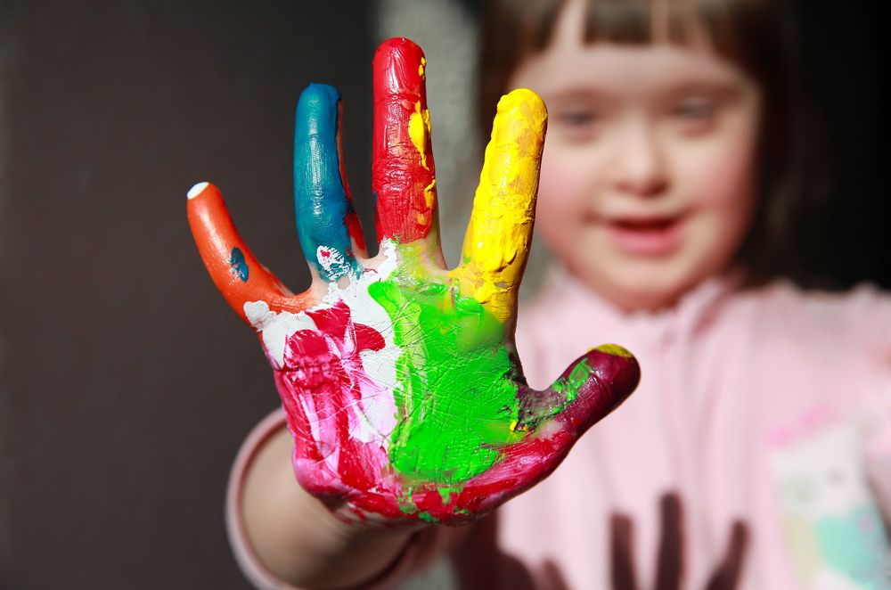 Bunte Hand von Kind mit Downsyndrom